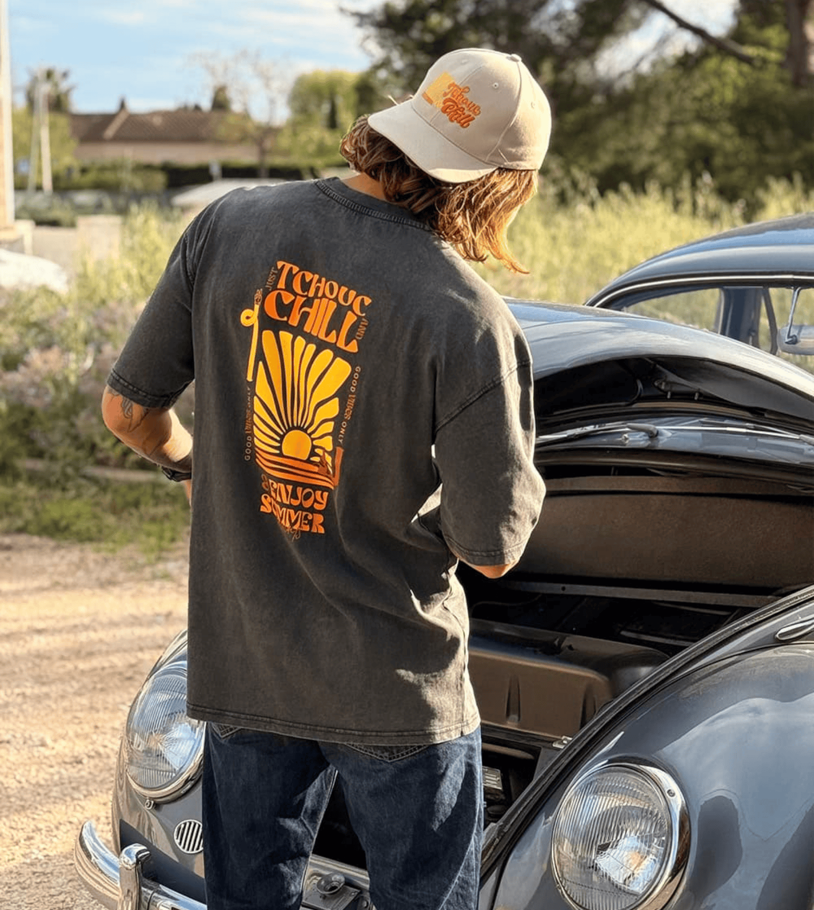 Homme en train de réparer une coccinelle Volkswagen portant un tee shirt oversize de la marque Tchouc & Chill
